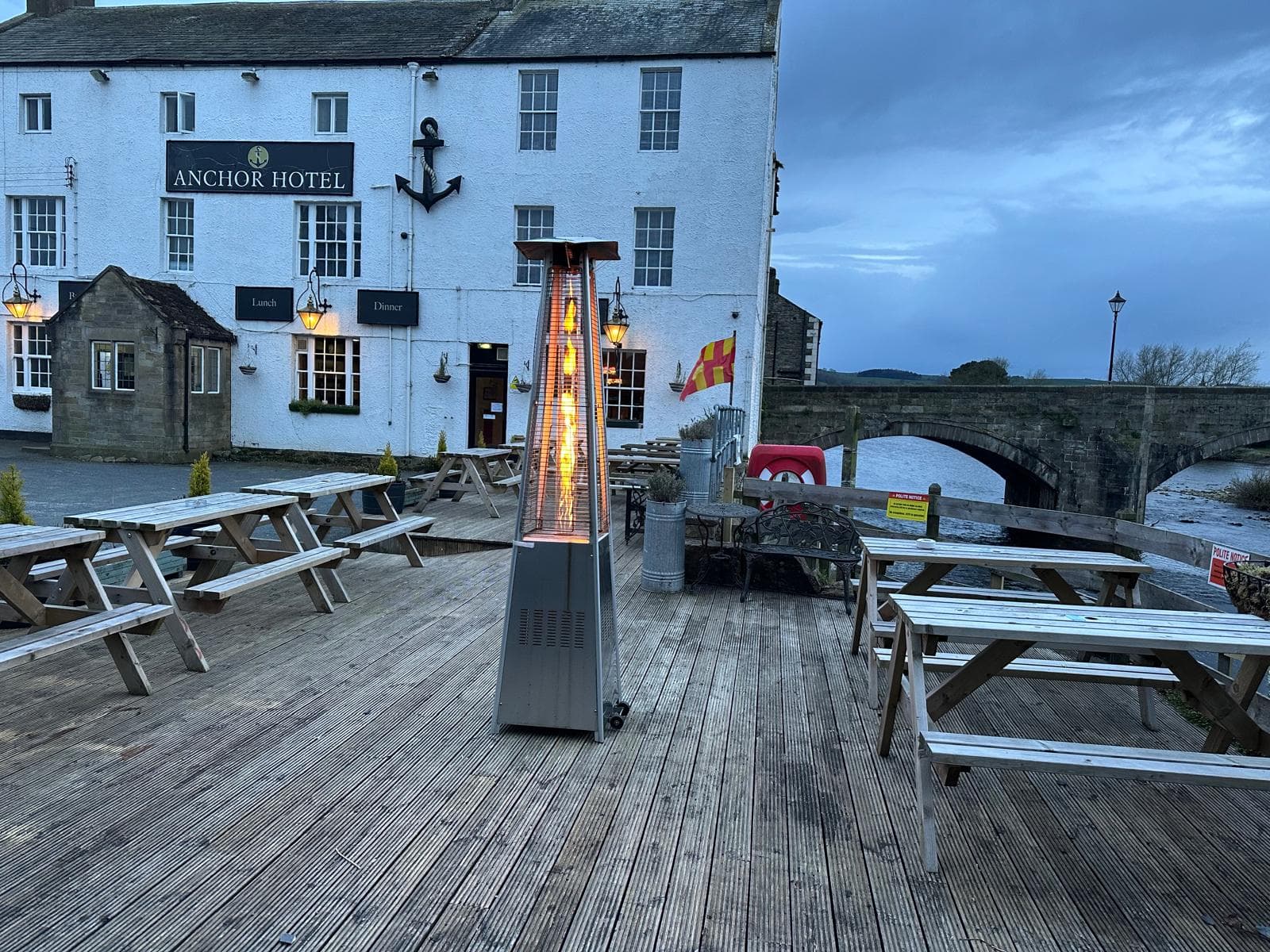 Evening view of the riverside terrace at The Anchor Hotel with outdoor heater